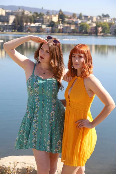 Φωτογραφία Δύο Λευκών Κοριτσιών Όμορφα Φορέματα Μπροστά Από Μια Λίμνη — Φωτογραφία Αρχείου