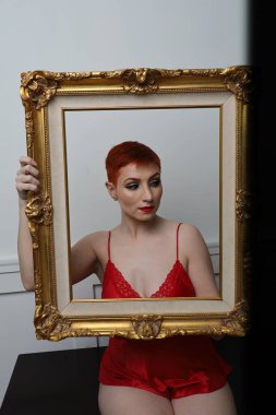 Güzel beyaz bir mankenin yatak odasındaki iç çamaşırlı fotoğrafı.