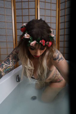 Küvette oturan güzel beyaz bir mankenin fotoğrafı.