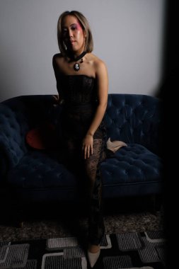 Kanepede kırmızı kalpli ve siyah dantelli güzel bir Vietnamlı mankenin fotoğraf çekimi.