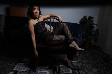 Kanepede oyuncak ayıyla güzel bir Vietnamlı mankenin fotoğrafı.