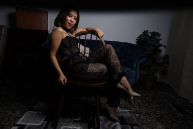 Kanepede oyuncak ayıyla güzel bir Vietnamlı mankenin fotoğrafı.