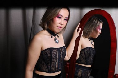 Tam boy aynanın önünde güzel bir Vietnamlı modelin fotoğrafı.