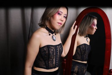 Tam boy aynanın önünde güzel bir Vietnamlı modelin fotoğrafı.