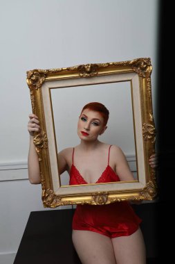 Güzel beyaz bir mankenin yatak odasındaki iç çamaşırlı fotoğrafı.