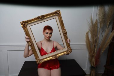 Güzel beyaz bir mankenin yatak odasındaki iç çamaşırlı fotoğrafı.