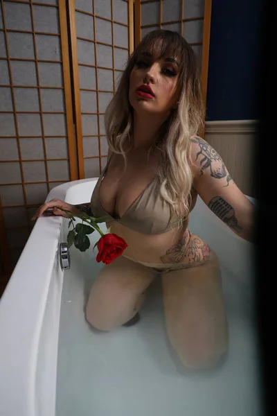 Photo Beautiful White Model Sitting Tub Holding Rose — ストック写真