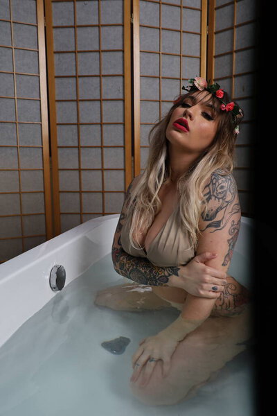 Photo of a beautiful white model sitting in a tub