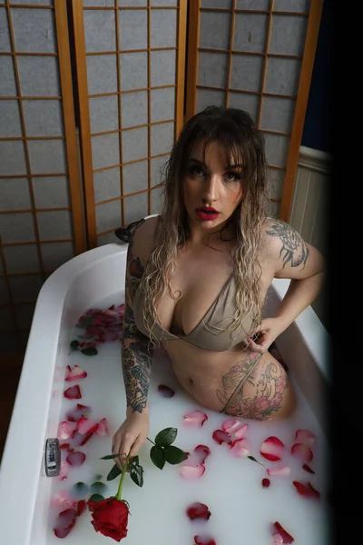 Photo Beautiful White Model Sitting Tub Milk Water Rose Petals — Stockfoto