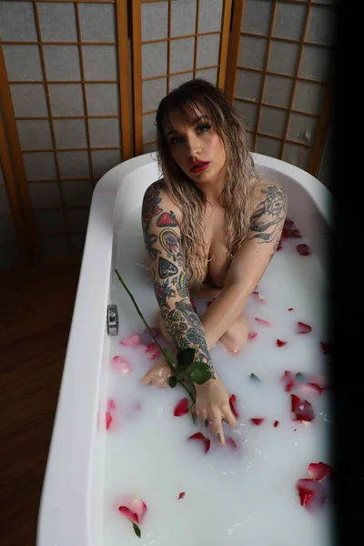 Photo Beautiful White Model Sitting Tub Milk Water Rose Petals — Zdjęcie stockowe
