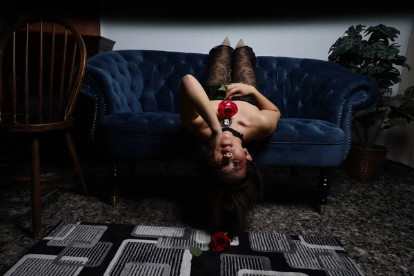 Güzel bir Vietnamlı mankenin elinde gülle kanepede otururken çekilmiş fotoğrafı.