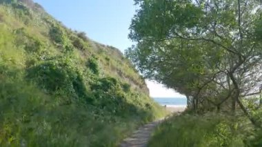 Sahilde ve sahil kenarında yürüyorum.