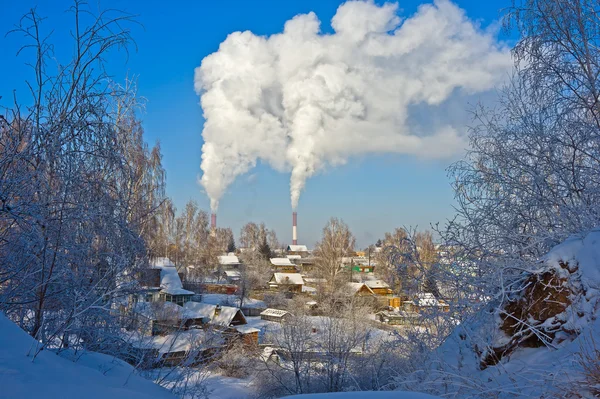 Fumar chaminés e casas de aldeia no inverno — Fotografia de Stock