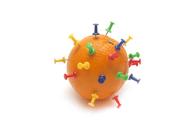 Colored pins stuck into an orange — Stock Photo, Image