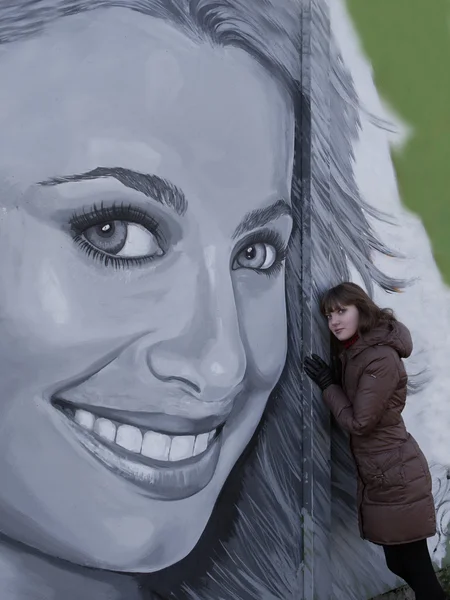 Siyah saçlı ayakta grafiti yakınındaki güzel kızla