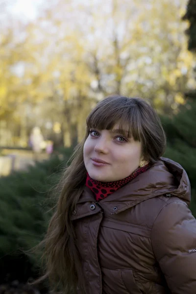 Beautiful young girl with dark hair and a brown coat — Stock Photo, Image