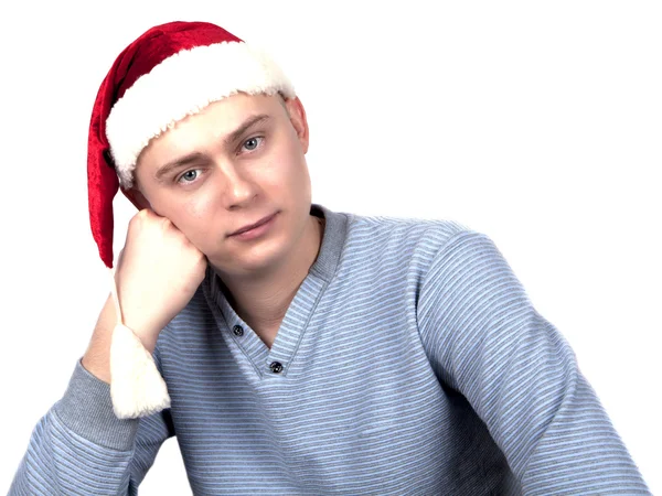 Young man in a Santa Claus hat and a blue sweater — Stock Photo, Image