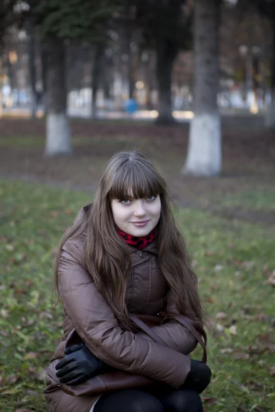 Beautiful young girl with dark hair and a brown coat — Stock Photo, Image