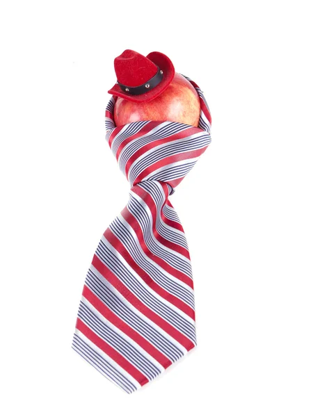 Композиція з яблука, червоної краватки і капелюха — стокове фото