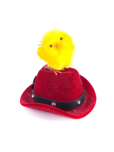 Toy chicken standing on a red hat — Stock Photo, Image