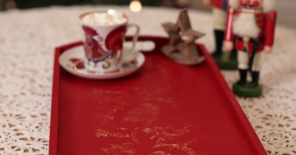 Винтажные ореховые крекеры и чашка зефирного какао на красном подносе с рождественскими огнями — стоковое видео
