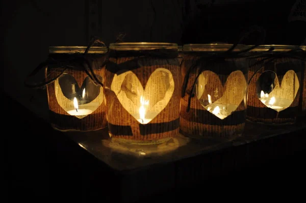 Handmade candle holders with cutout hearts and glowing tea lights inside — Stock Photo, Image