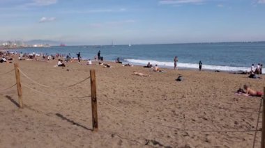 Pan deniz manzaralı turistler Barceloneta İspanya 'daki Sant Miquel plajında güneşleniyorlar.