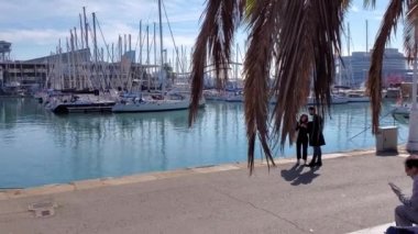 Turistler Barselona İspanya 'da deniz kıyısında ünlü ve keyifli bir yürüyüş yolu boyunca yürüyorlar.