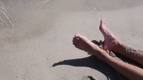 Child splash adult with sea water closeup. Drops fall in clean white sand on beach. Sea surf — Stock Video