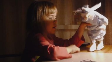 küçük kızın bir melek bir bebekle oynuyor. çekim dolly bez-bebek kız çocuk melek dizisi