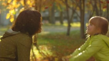 mutlu anne ve küçük kızı yavaş çekim dizi atmak sonbahar yaprakları.