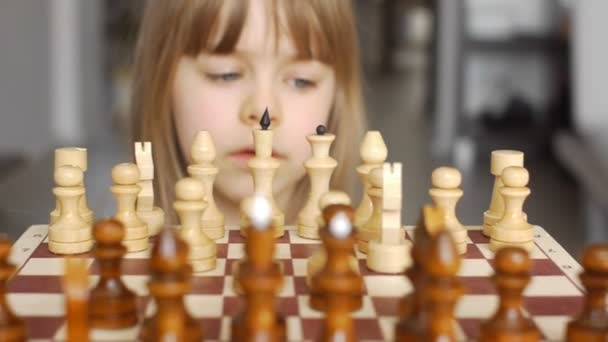 Beautiful little girl learns to play chess — Stock Video