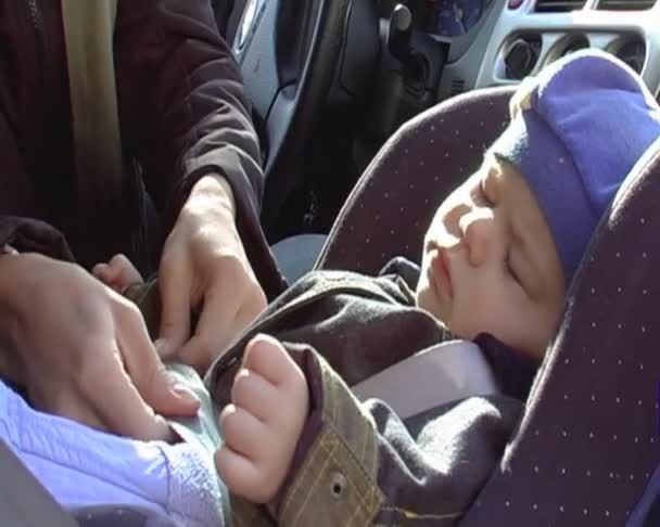 La giovane donna fissa il bambino in un seggiolino auto. Sequenza di spari. Schermo anamorfico panoramico — Video Stock