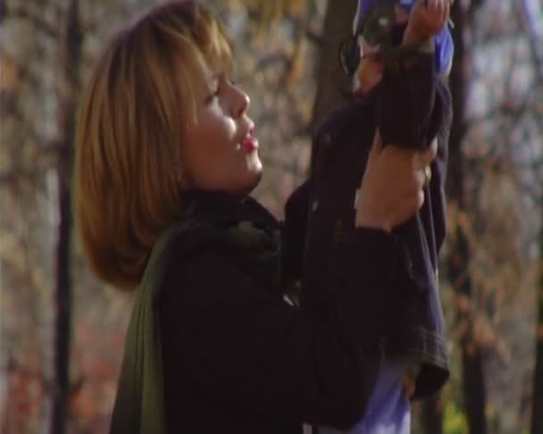 The young woman walks with the baby in park.Anamorphic wide-screen — Stock Video