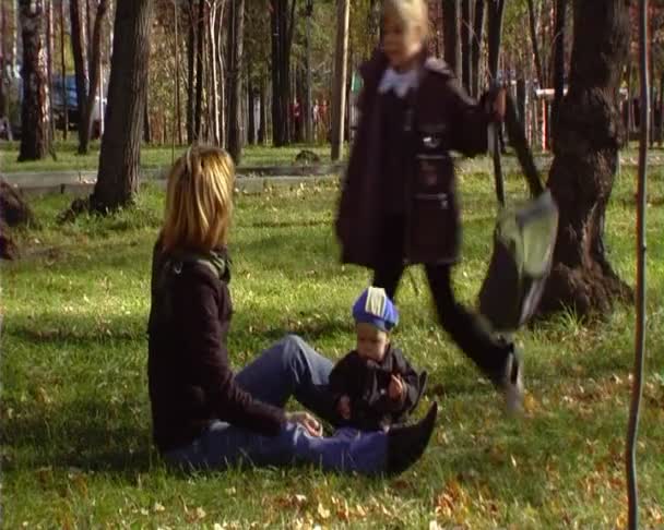 A jovem caminha com o bebê no parque.Tela larga anamórfica — Vídeo de Stock