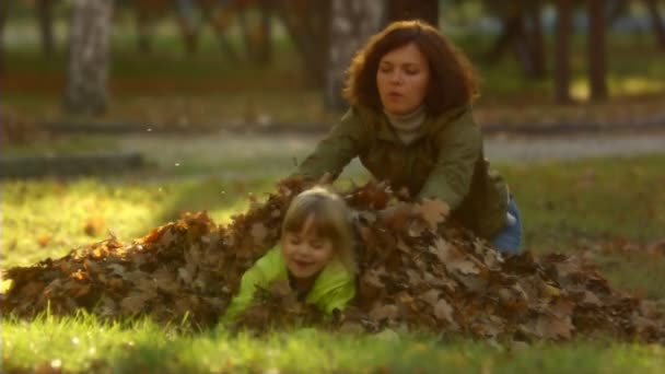 Sequenz von Zeitlupenaufnahmen glückliche Mutter und das kleine Mädchen werfen Herbstblätter. — Stockvideo