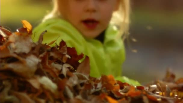 Slagsekvens ultrarapid glad mamma och den lilla flickan kasta hösten lämnar. — Stockvideo