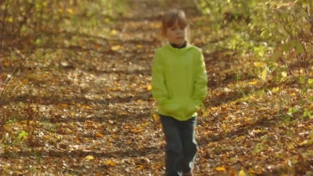 Petite fille marche dans la ruelle d'automne. Mouvement lent .