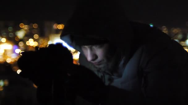 De fotograaf werkt op een dak van een wolkenkrabber. — Stockvideo
