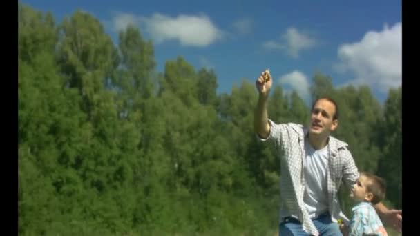 De man met het kind vliegen vlieger. Slow motion — Stockvideo