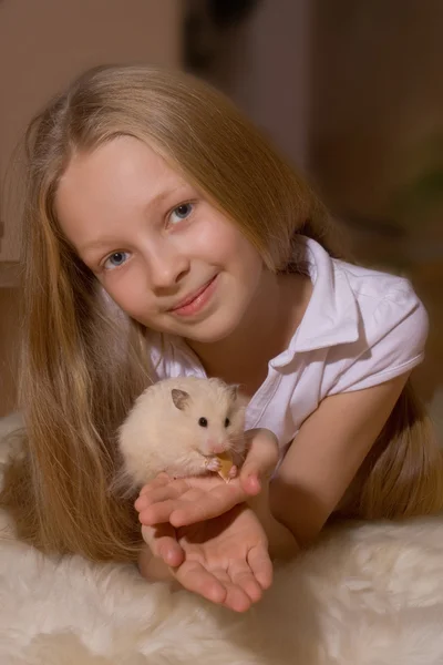 Sarı saçlı bir hamsterlittle holding ile küçük kız