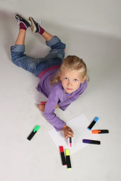 Das kleine Mädchen mit den blonden Haaren zeichnet — Stockfoto