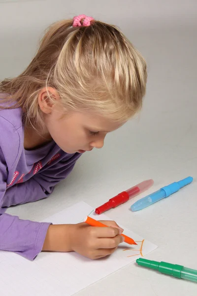 Het kleine meisje met blond haar trekt — Stockfoto