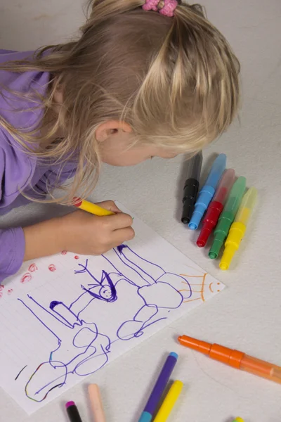 Das kleine Mädchen mit den blonden Haaren zeichnet — Stockfoto