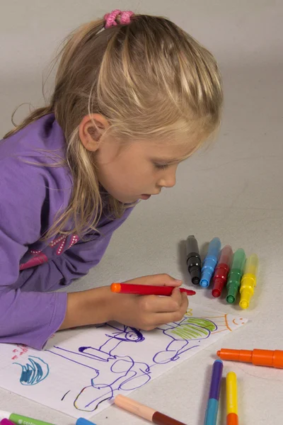 Das kleine Mädchen mit den blonden Haaren zeichnet — Stockfoto