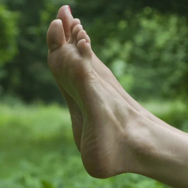 緑の背景に女性の足 — ストック写真