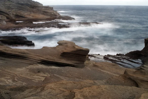 Волны бьются по береговым скалам — стоковое фото
