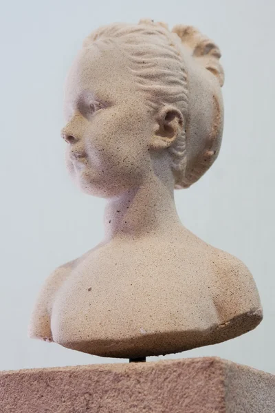 Chica en un busto de piedra —  Fotos de Stock