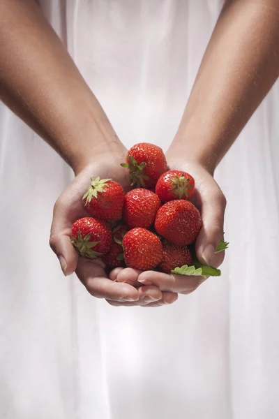 Mujer joven sosteniendo fresas — Foto de Stock