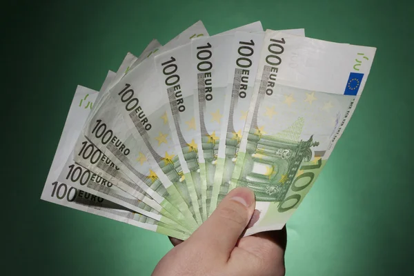 Mans hand med euro på grön bakgrund — Stockfoto
